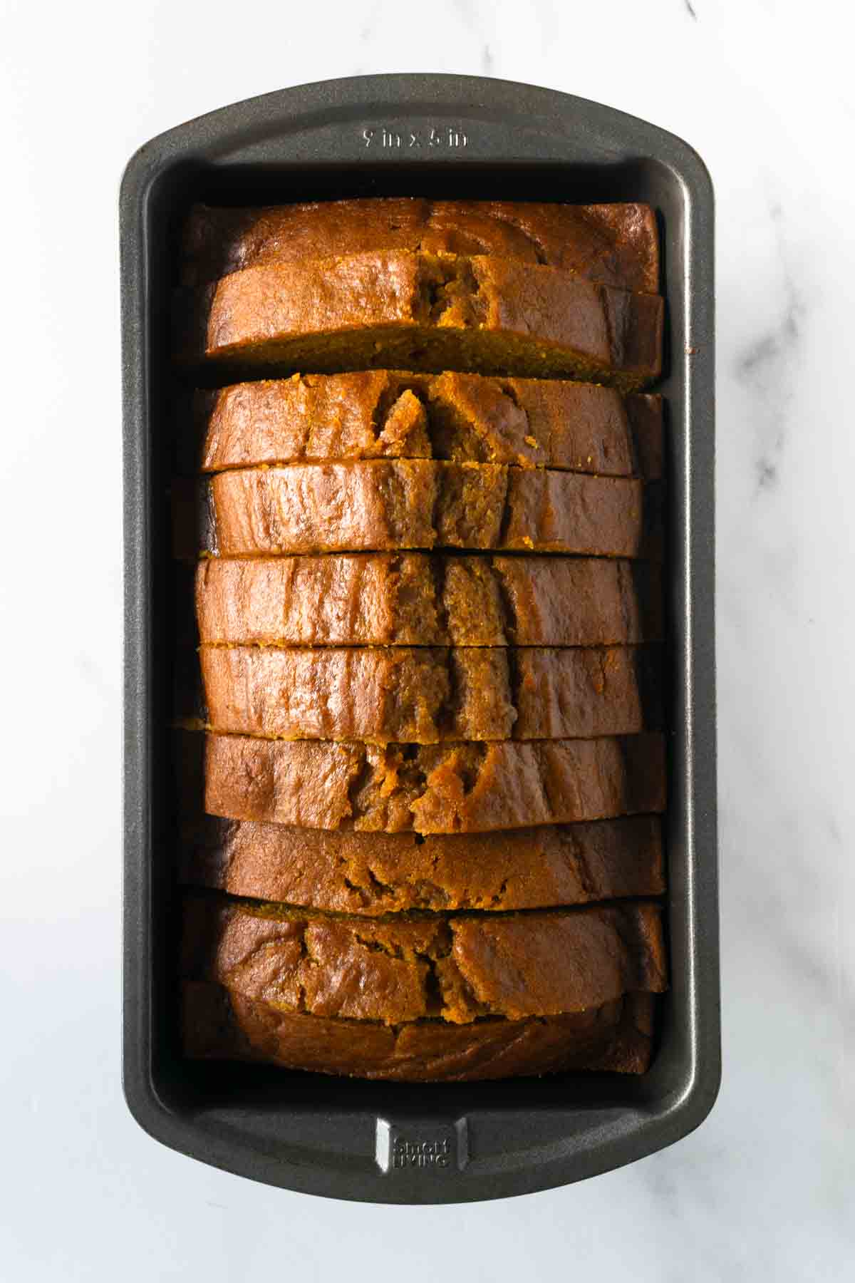 baked pumpkin bread slices in a loaf pan.