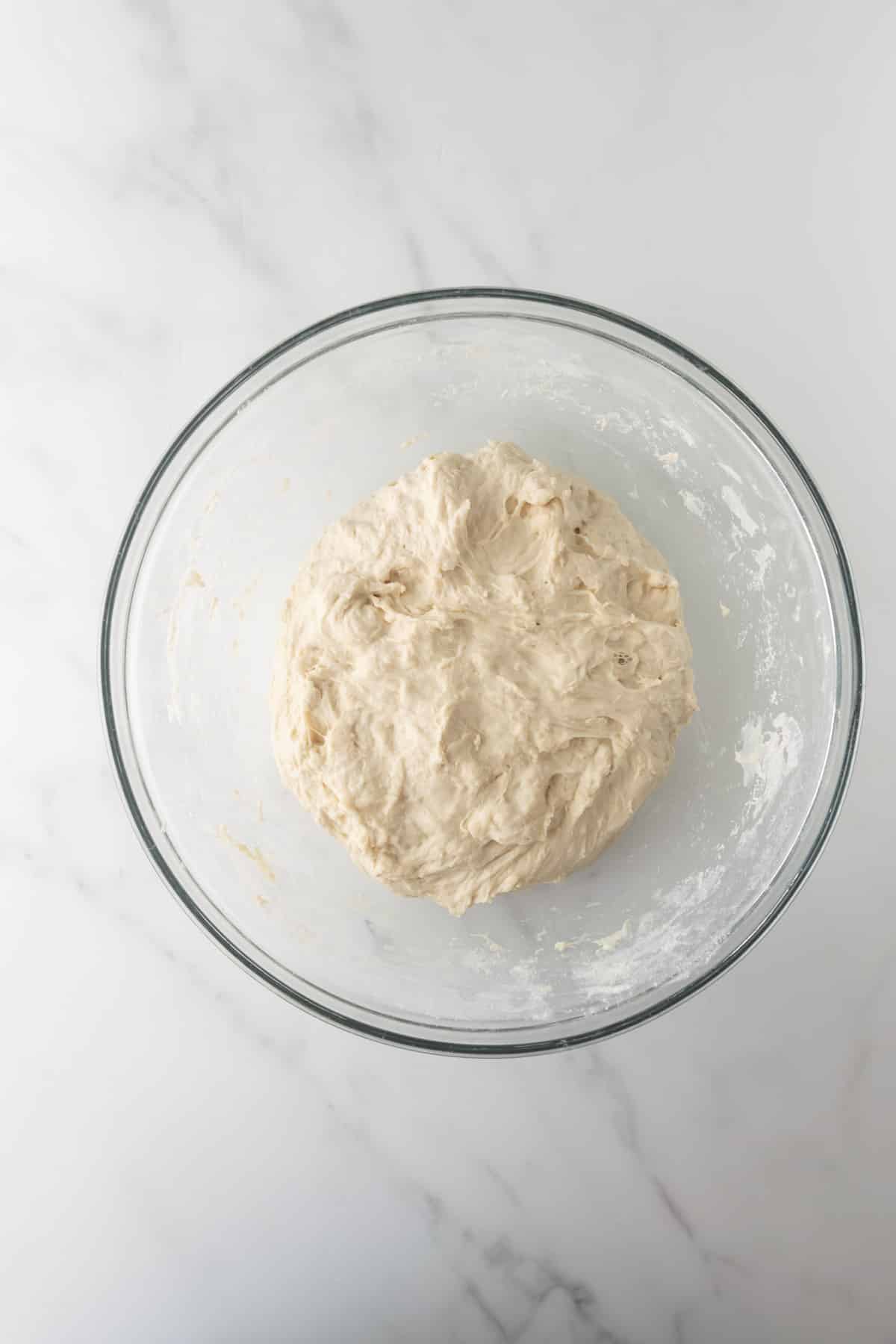 shaped bread dough in a glass mixing bowl.