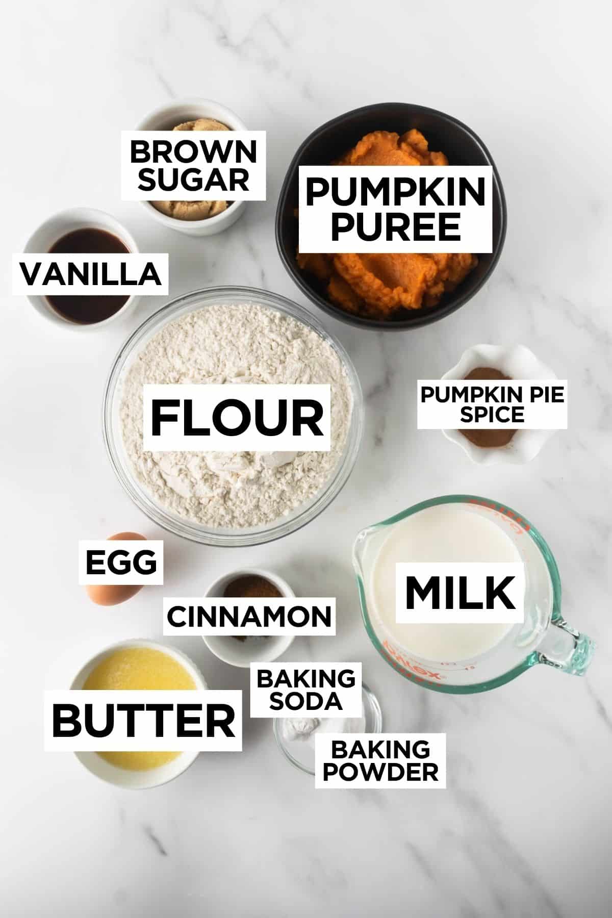 ingredients for pumpkin pancakes in bowls on a white table with overlay text.