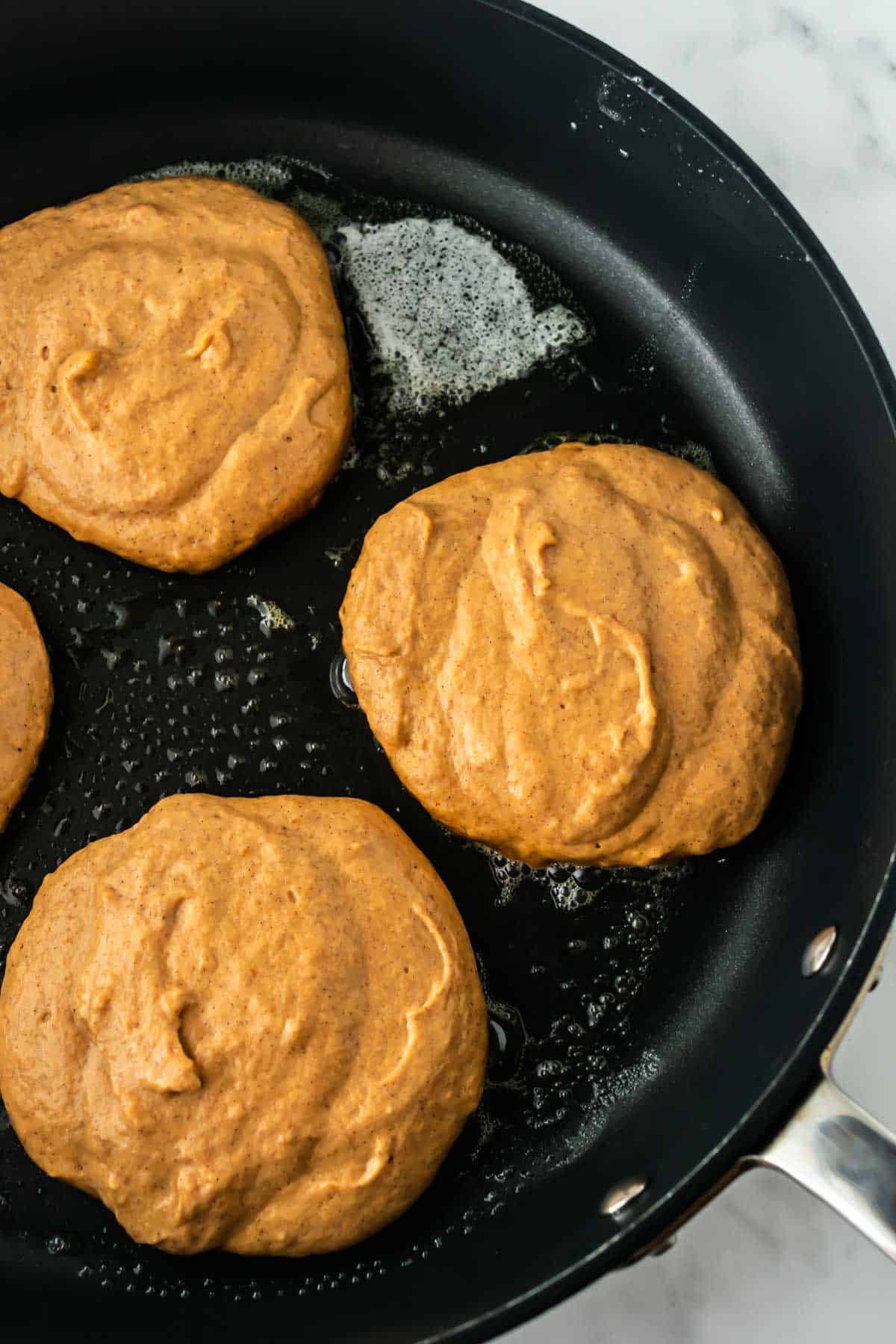 pancake batter in a black pan.