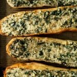 slices of garlic bread topped with herbs.