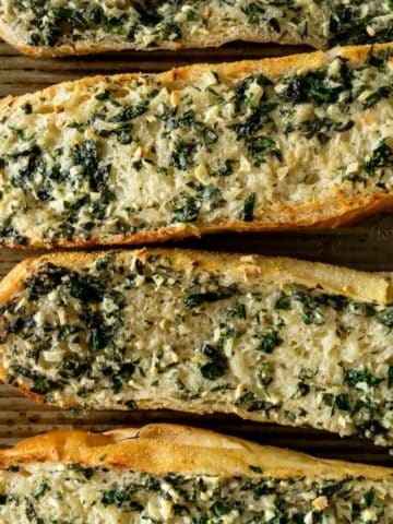 slices of garlic bread topped with herbs.