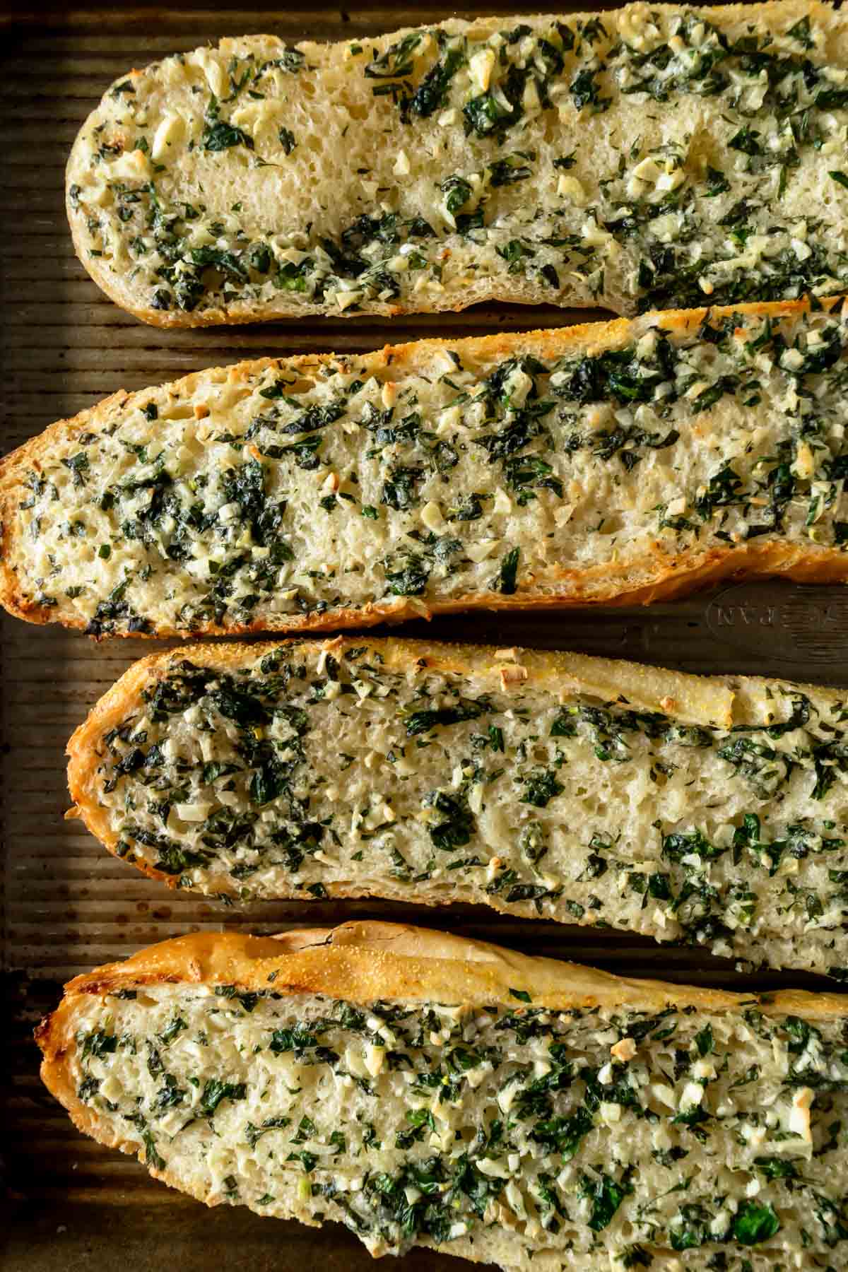 slices of homemade garlic bread on a baking sheet.