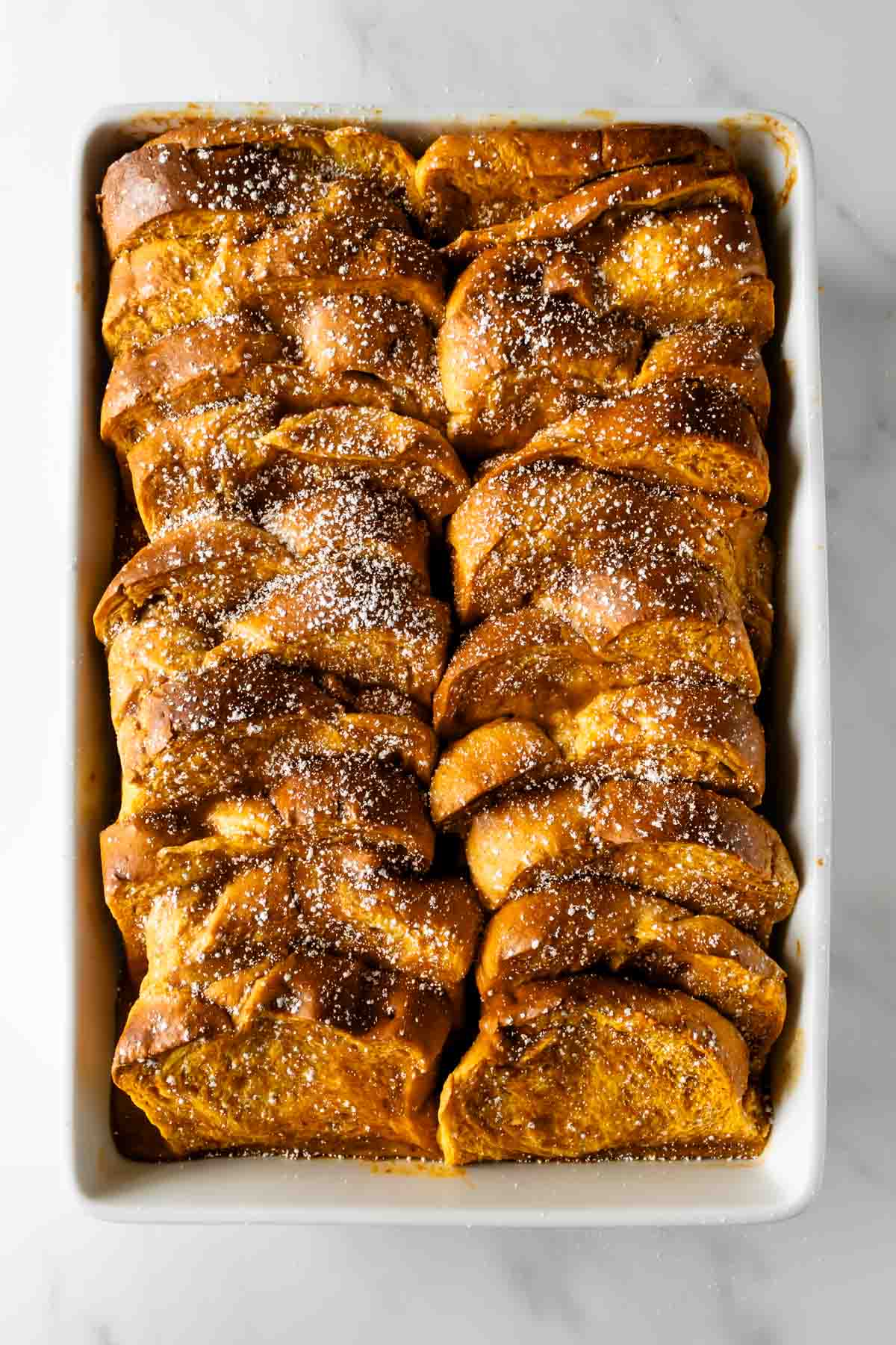 pumpkin French toast casserole topped with powdered sugar.