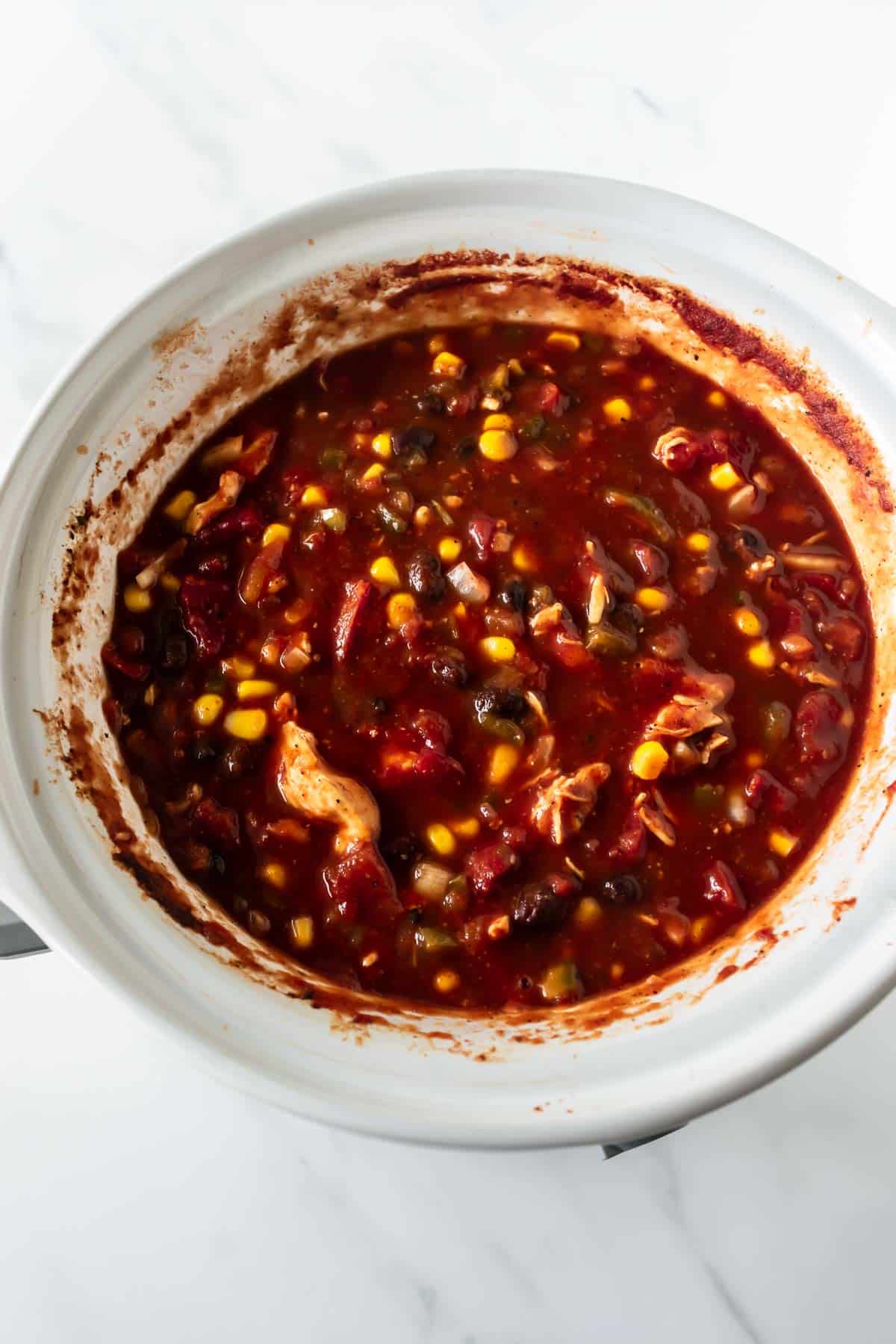 slow cooker red chicken chili in a white slow cooker.