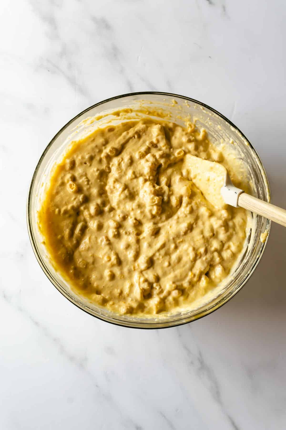 corn casserole batter with a spatula in a bowl.