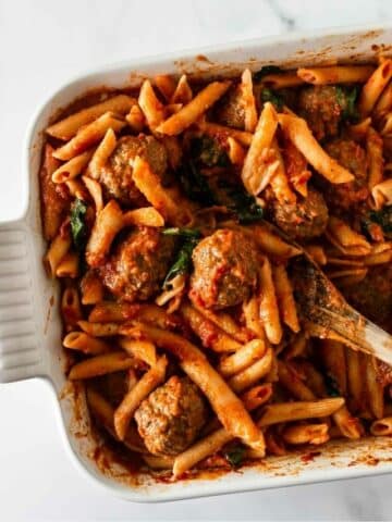 penne pasta and meatballs in a baking dish.