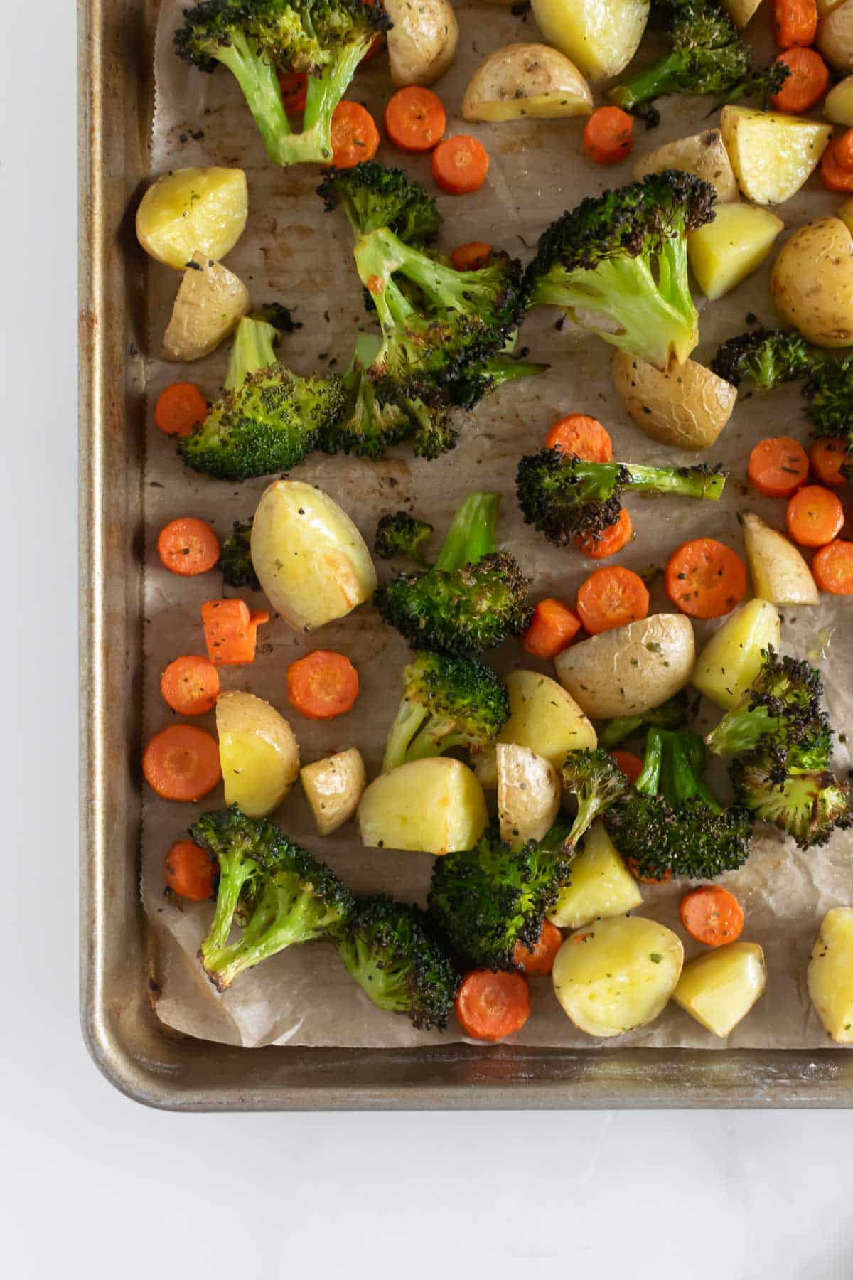 cooked vegetables and potatoes on a baking sheet.