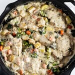 creamy garlic chicken and vegetables with a cream sauce in a skillet.