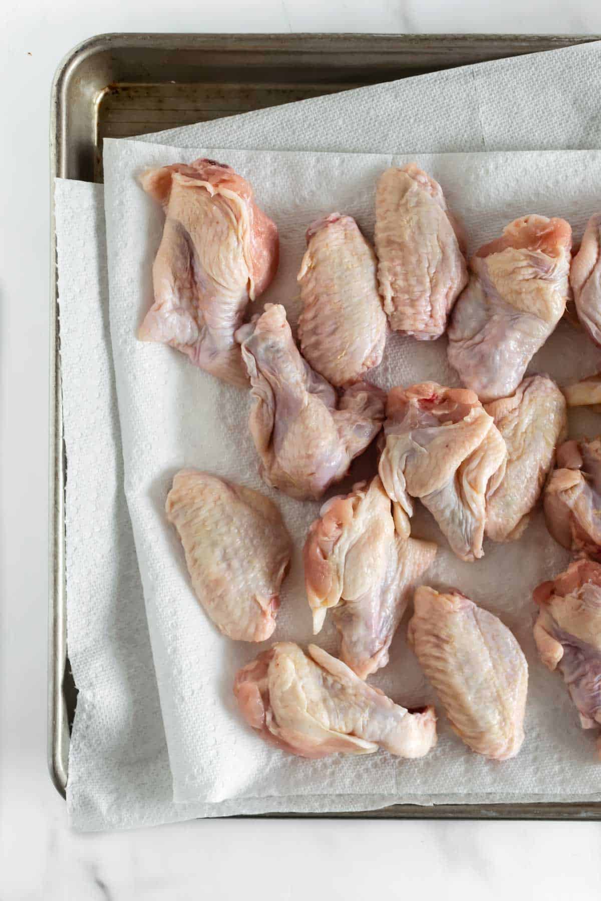 chicken wings on a baking sheet lined with paper towels.