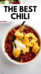 cornbread on top of a bowl of chili with a spoon with overlay text.