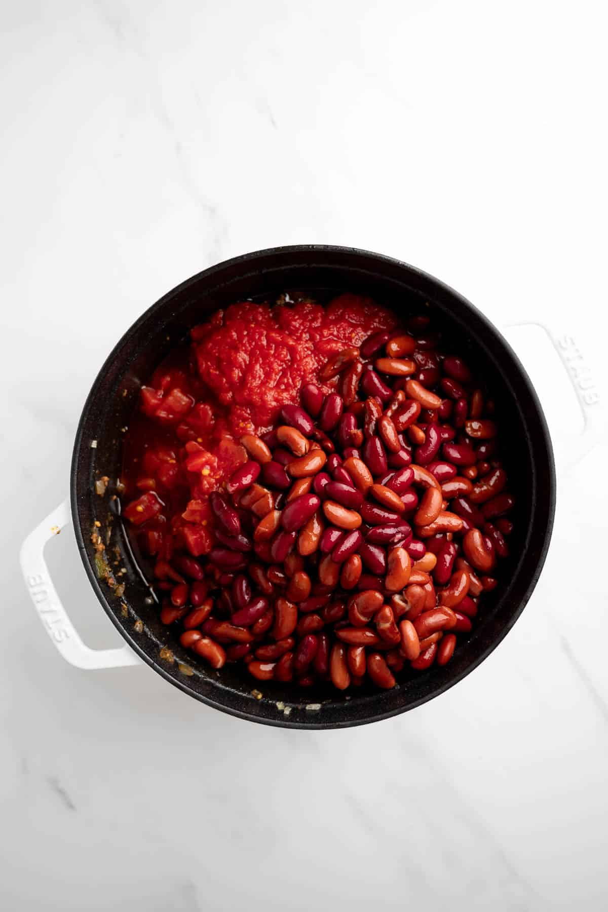 red kidney beans, tomatoes and crushed tomatoes in a pot.