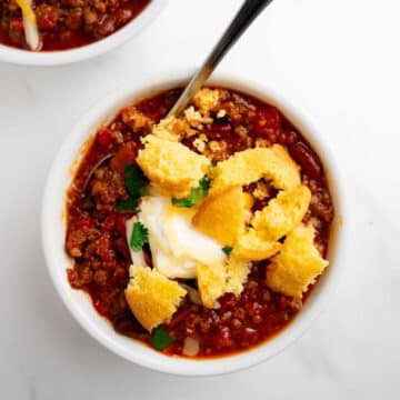 chili in a bowl topped with cornbread.