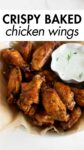 baked chicken wings in a bowl with ranch dressing with overlay text.