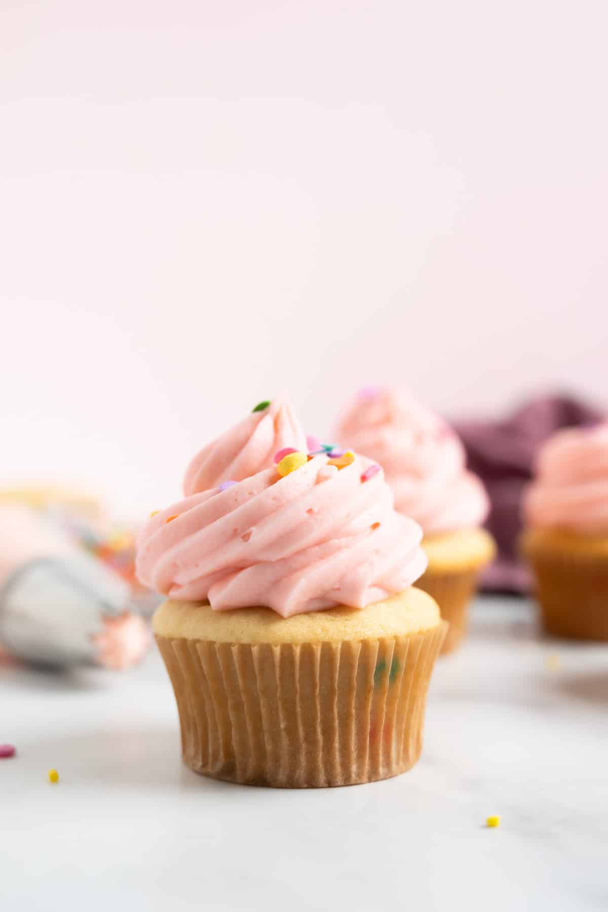 a funfetti cupcake topped with pink frosting and sprinkles.