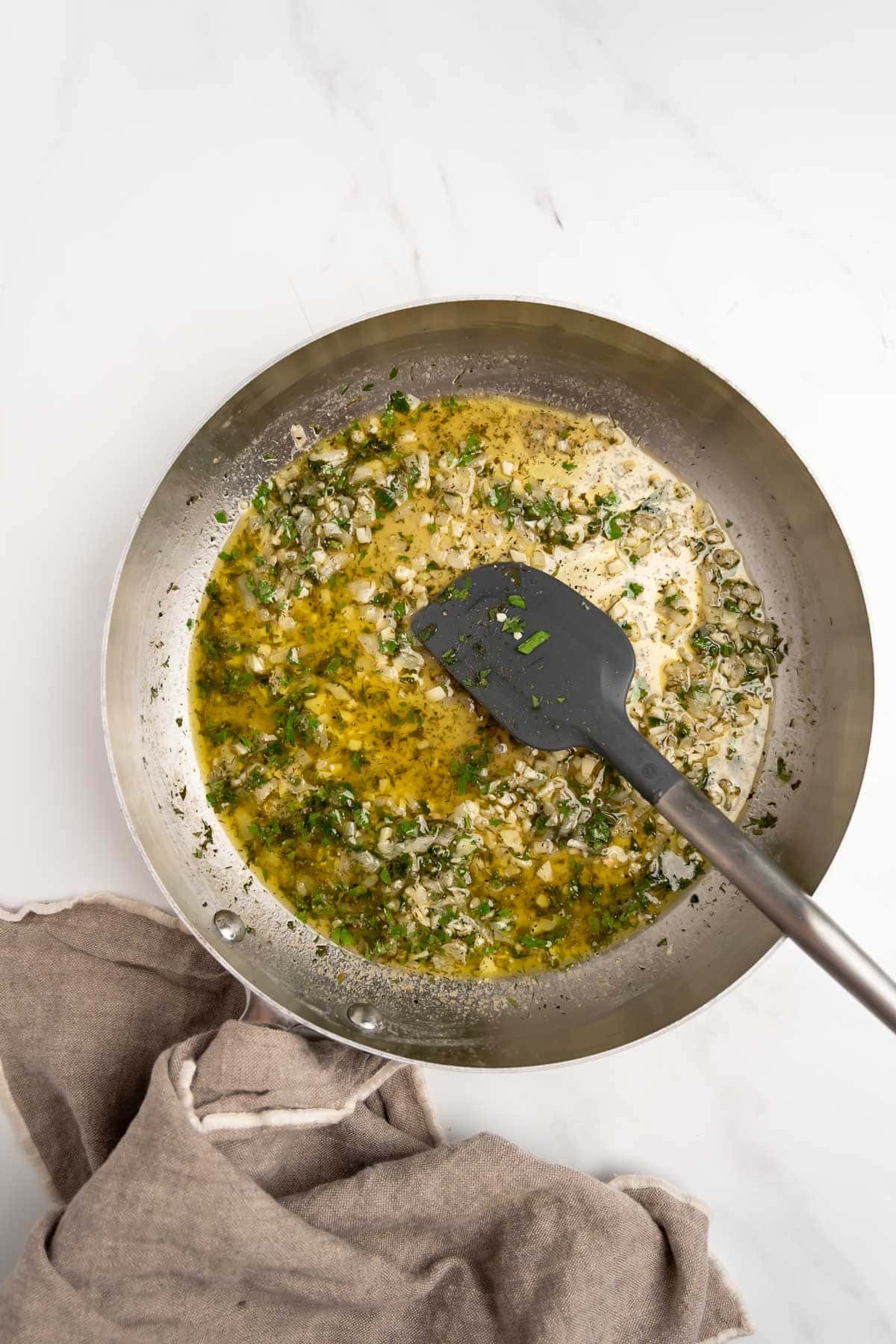lemon garlic herb sauce in a pan with a spatula.