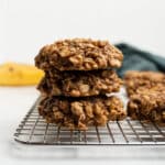 stacked peanut butter banana oatmeal cookies on a cooling rack.