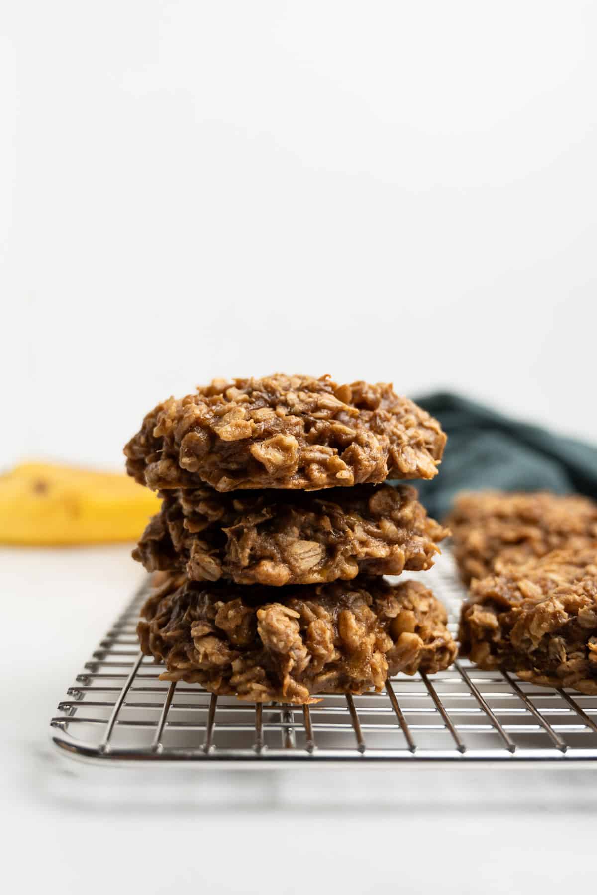 3 stacked peanut butter banana oatmeal cookies on a cooling rack.
