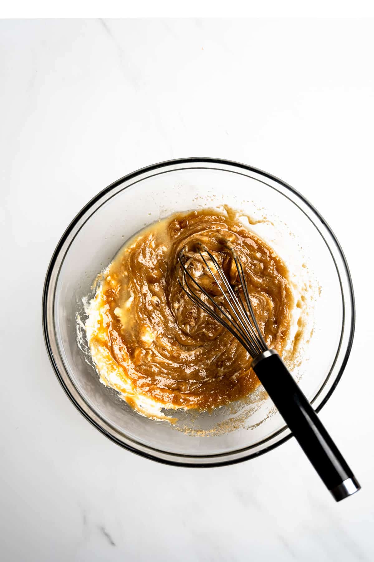 wet ingredients mixed together in a bowl with whisk.