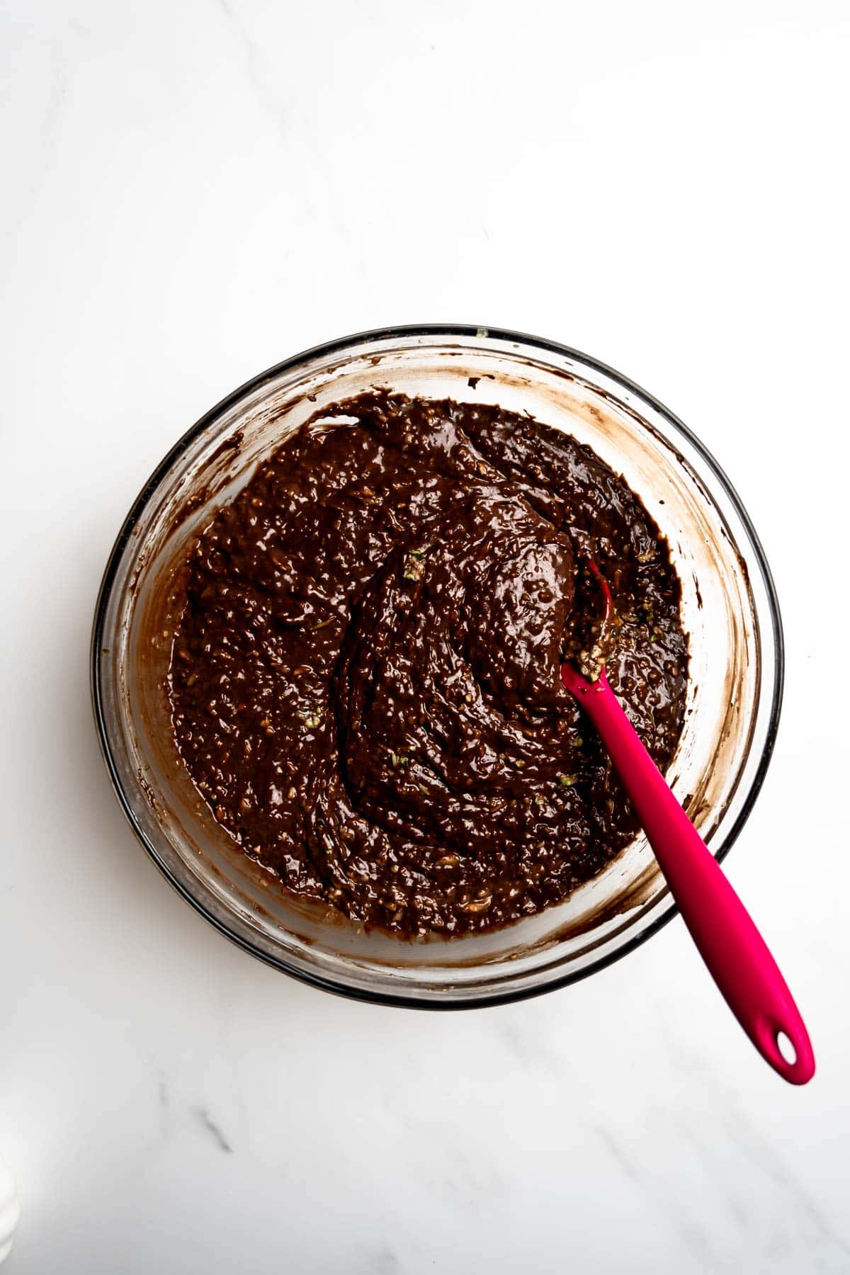 chocolate cake batter mixed with shredded zucchini in a bowl.