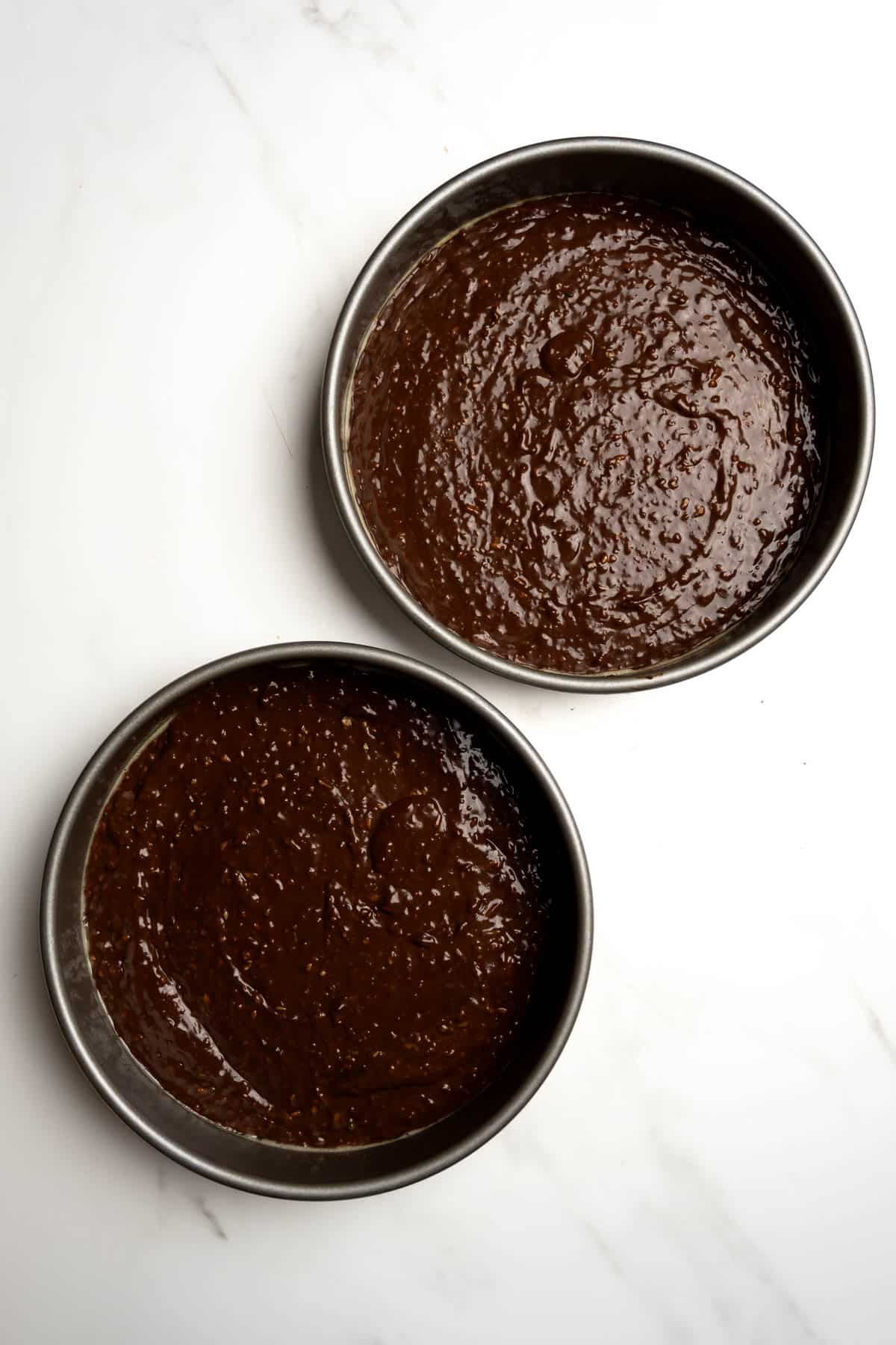 chocolate cake batter in two round cake pans.