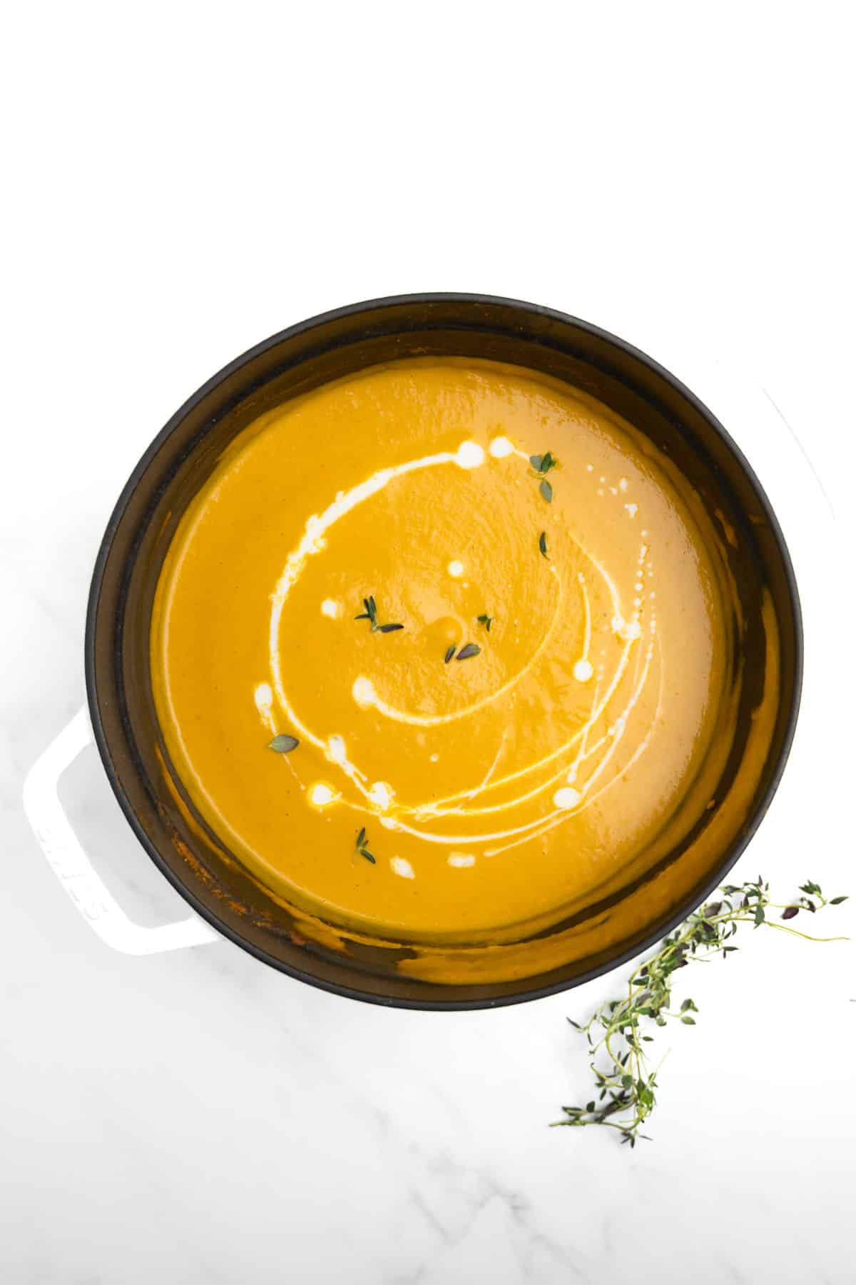 pumpkin soup in a black and white pot.