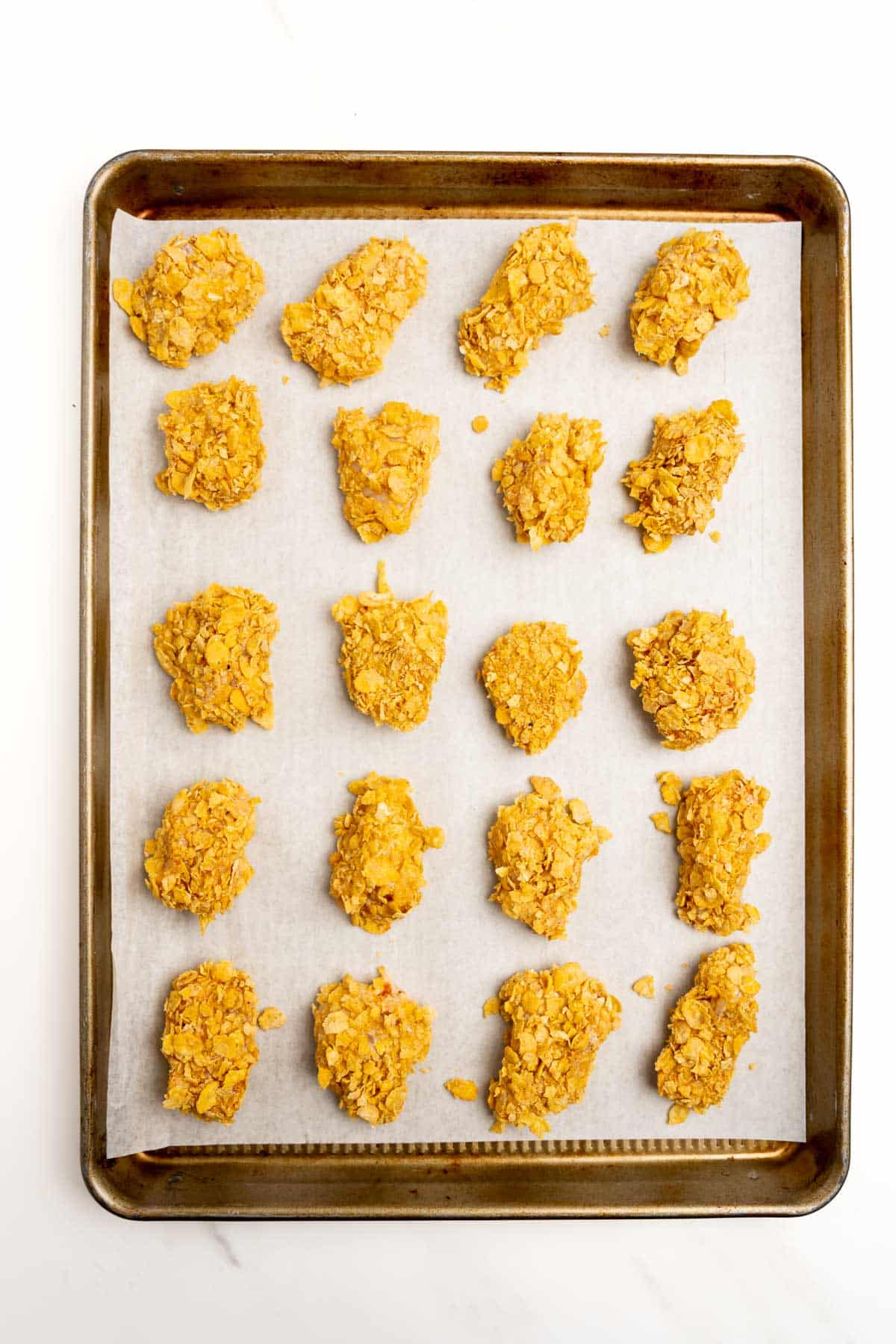 unbaked boneless buffalo chicken bites on a baking sheet.