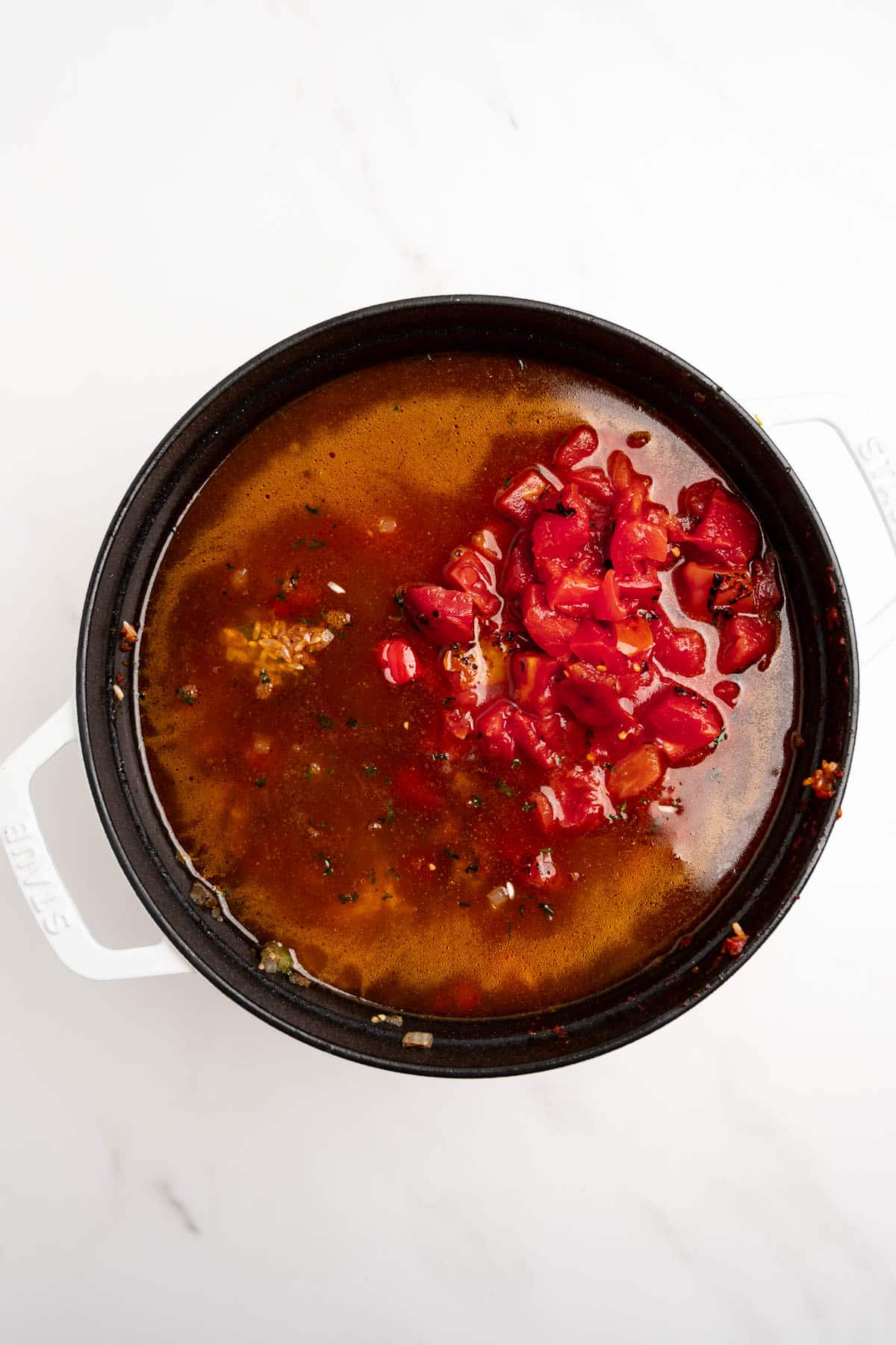 ground beef, peppers, broth and tomatoes in a dutch oven.