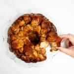 pulling a piece of monkey bread on a plate.
