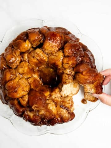 pulling a piece of monkey bread on a plate.