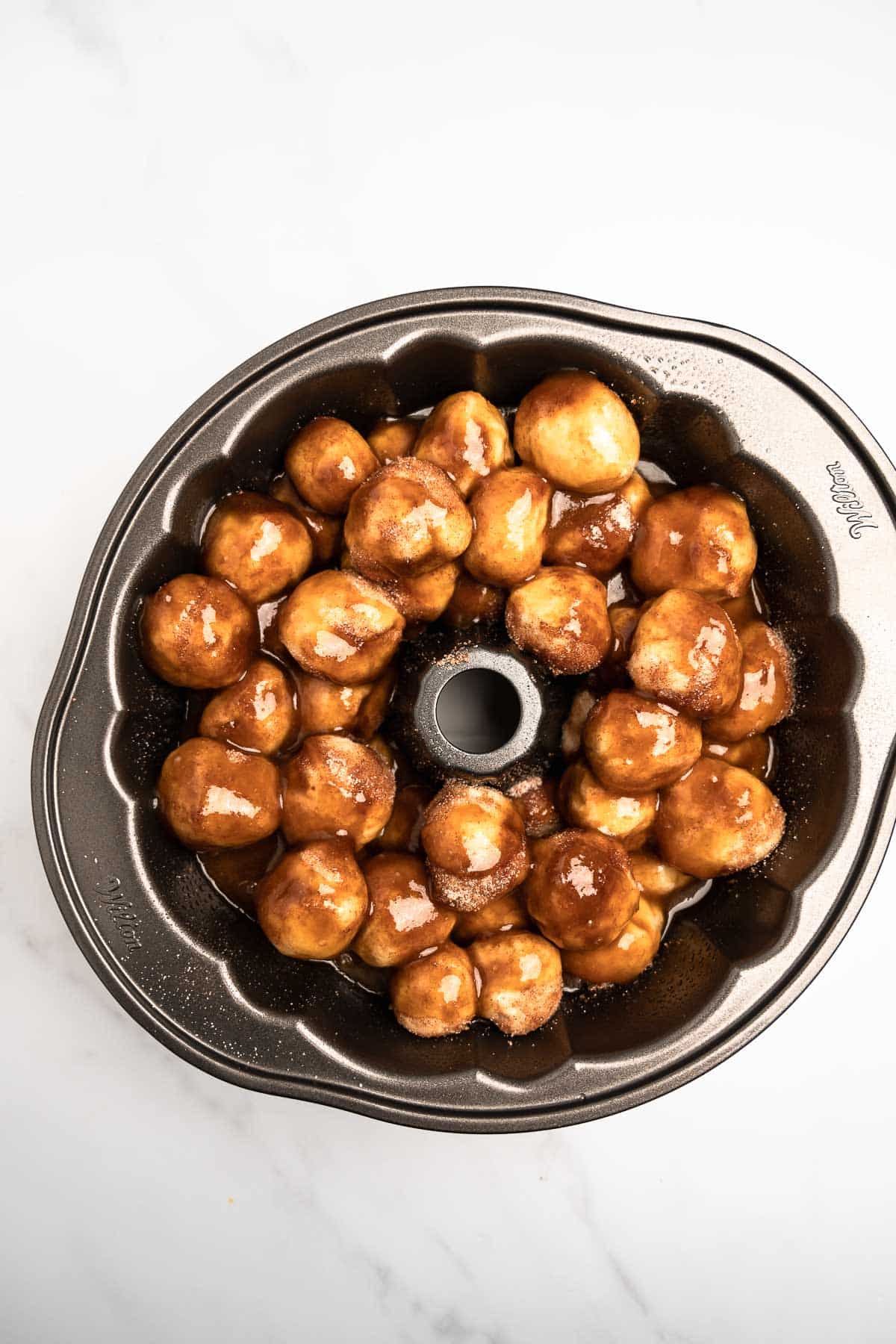 cinnamon sugar dough balls with brown sugar sauce in a Bundt pan.