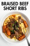 pulled short ribs over polenta with carrots in a bowl.