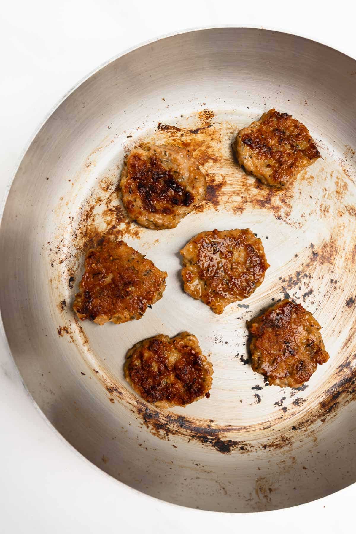 maple chicken sausage patties in a skillet.