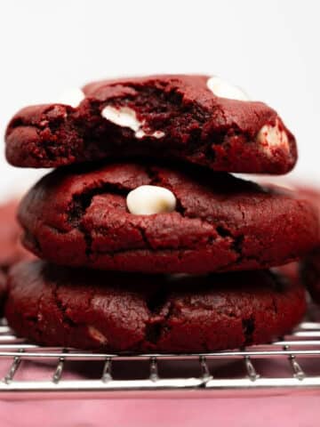 stacked red velvet cookies with white chocolate chips.