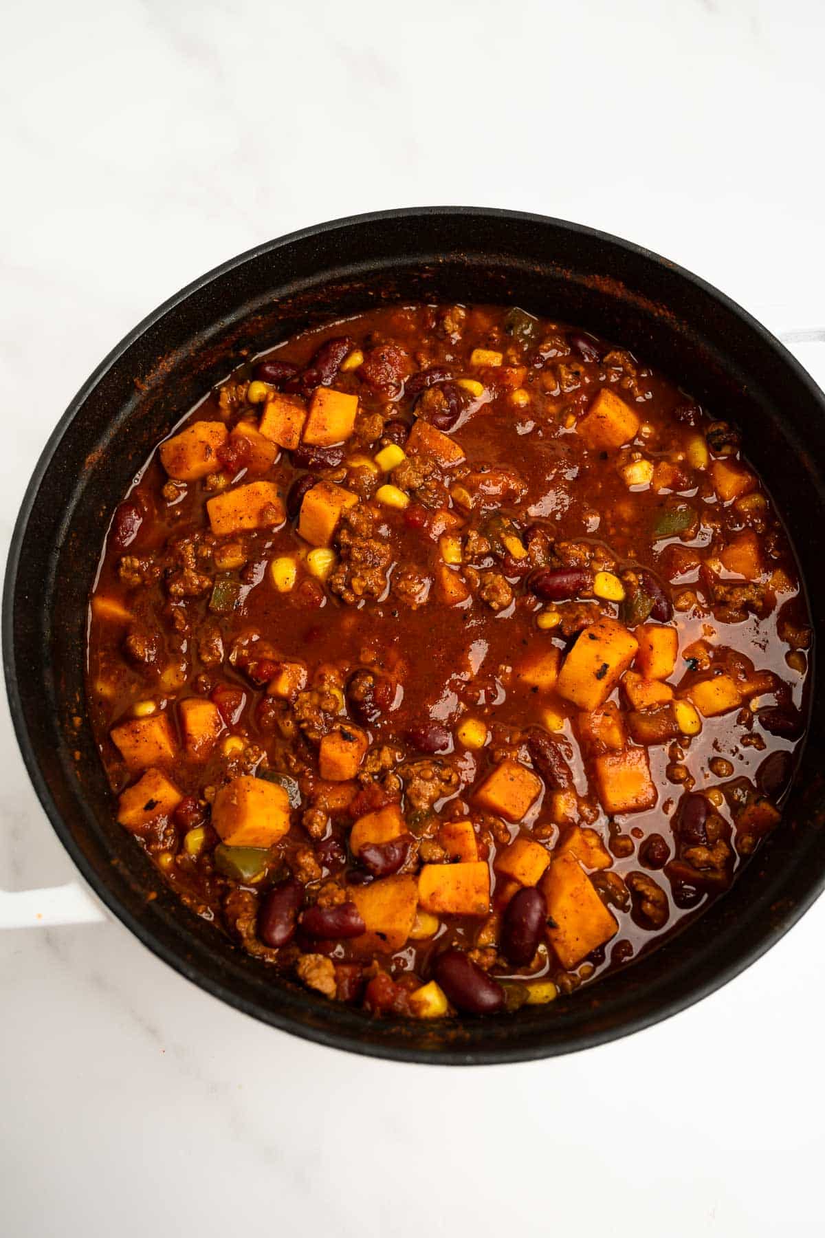 cooked sweet potato turkey chili in a black pot.