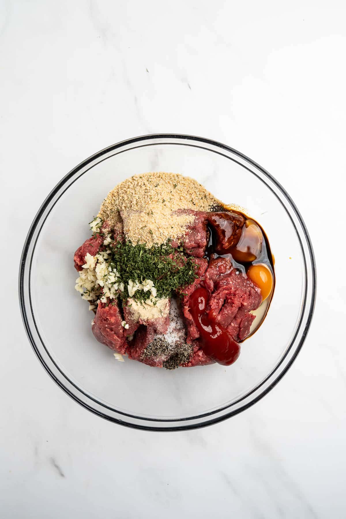 ingredients for meatloaf recipe in a large glass bowl.