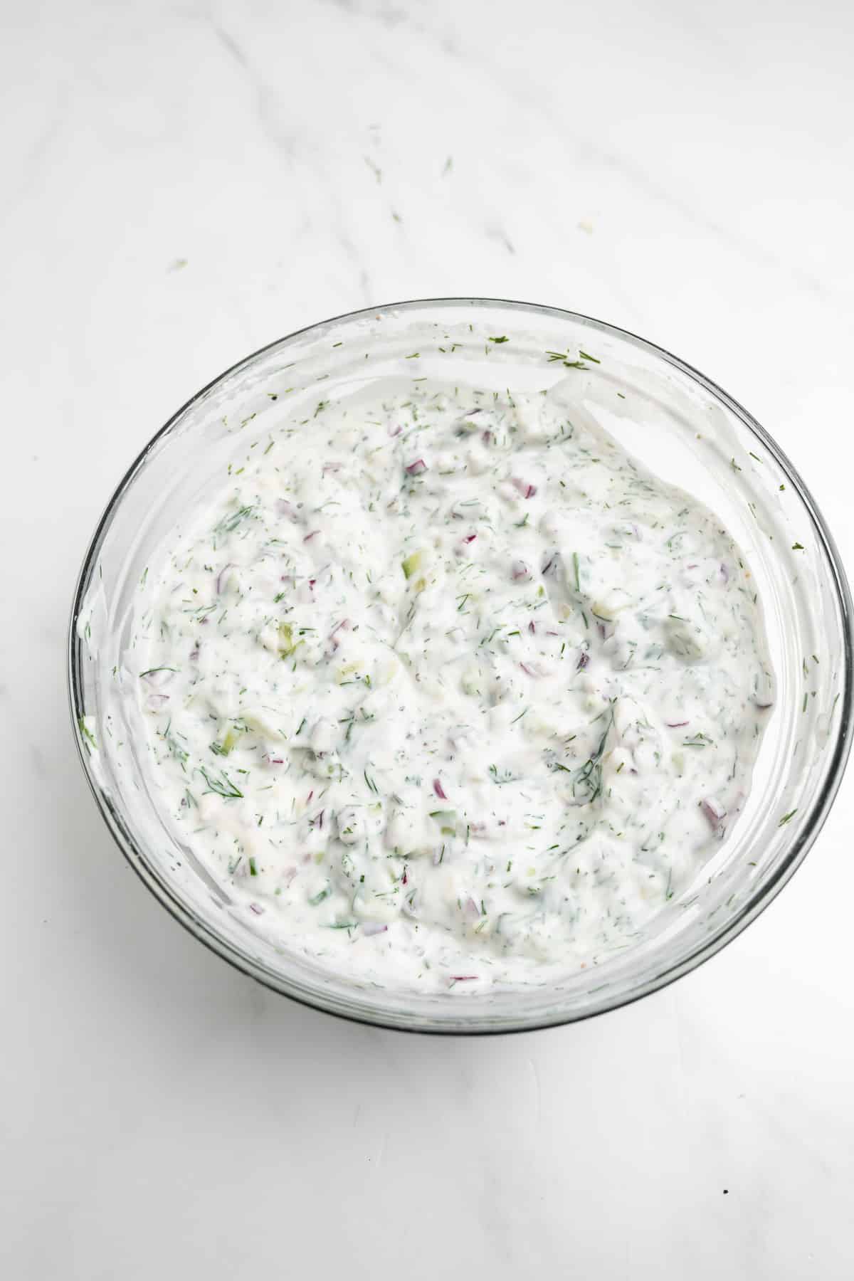 Mixed tzatziki sauce ingredients in a bowl.