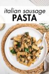 Italian sausage pasta on a plate with a fork and overlay text.
