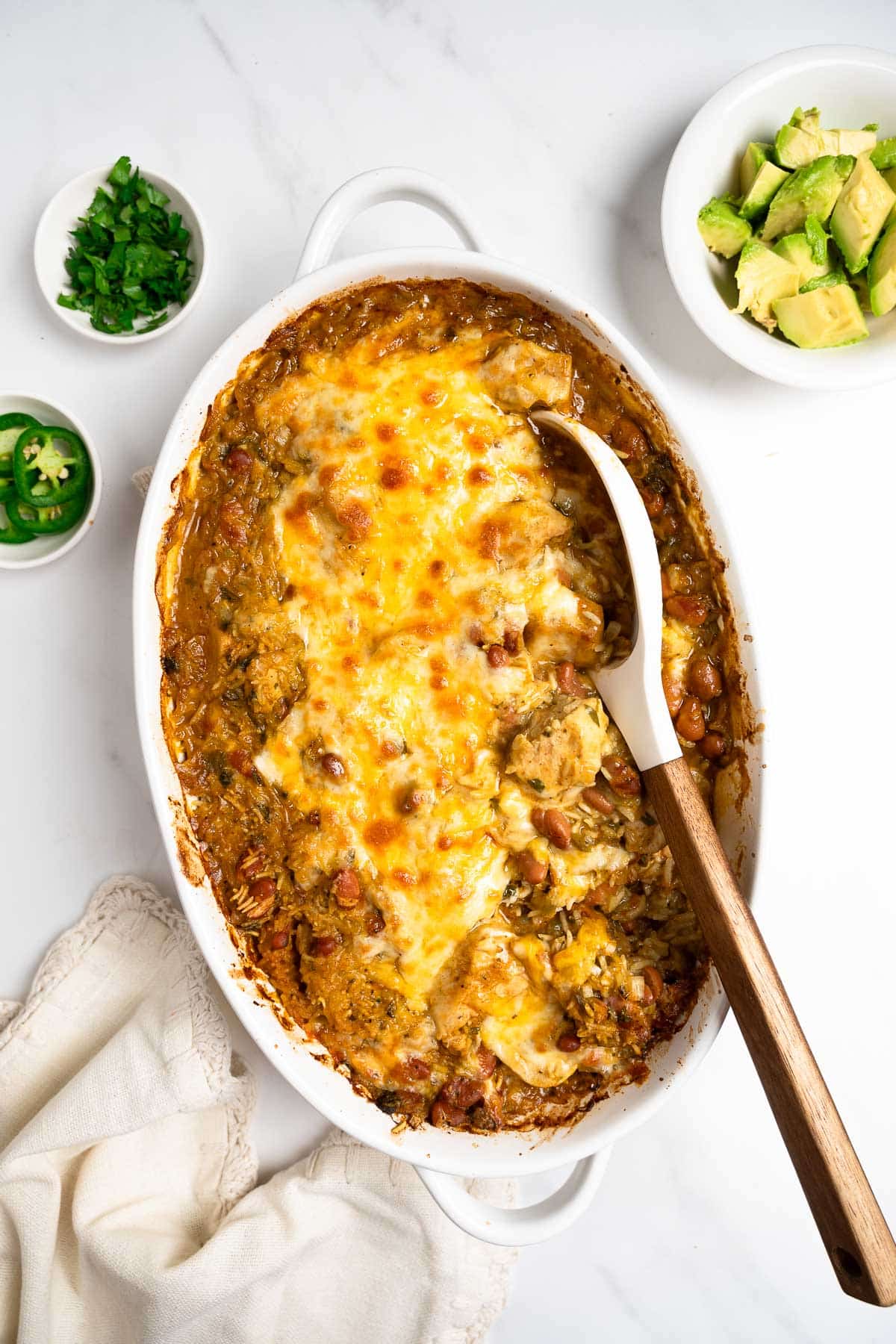 salsa verde chicken bake topped with cheese in a baking dish.